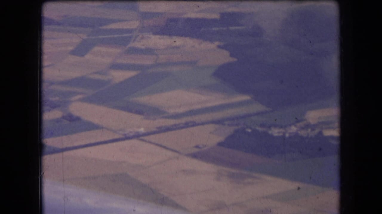 Overhead farmland with rectangular fields and a small rural settlement area.