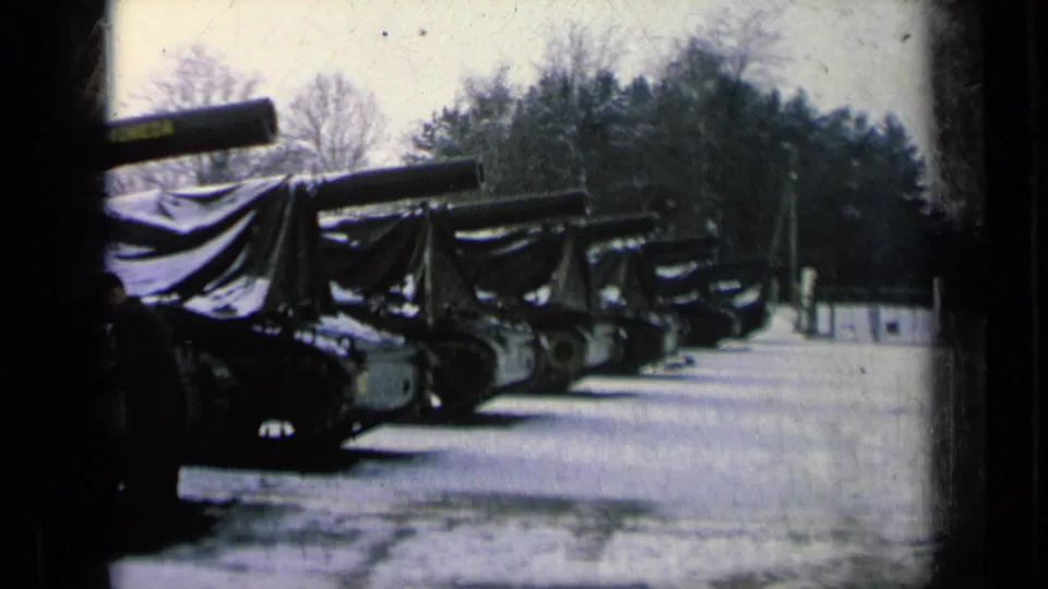 The final frame shows a longer view of tarp-covered military tanks lined up in snow, with forested background and overcast light.
