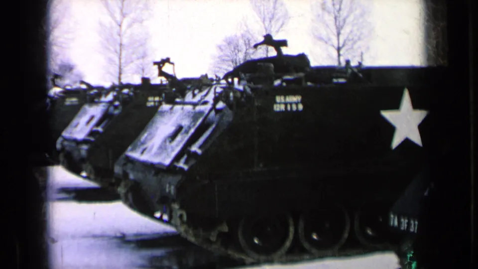 Close 8mm view of a U.S. Army armored personnel carrier marked with a white star on a Germany base in 1963.