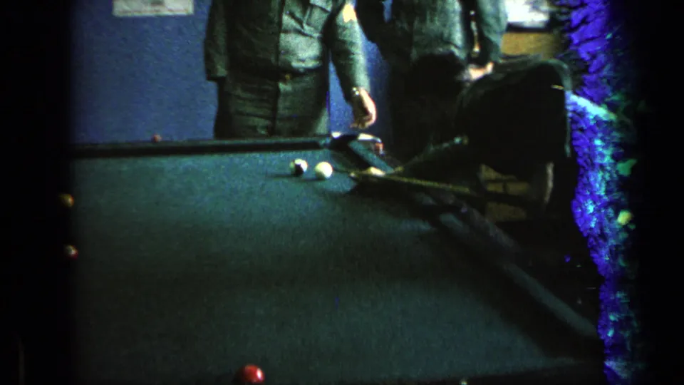 The pool-room view continues with uniformed men near the table, dark vignetting, and vivid 8mm color shifts at the frame edge.