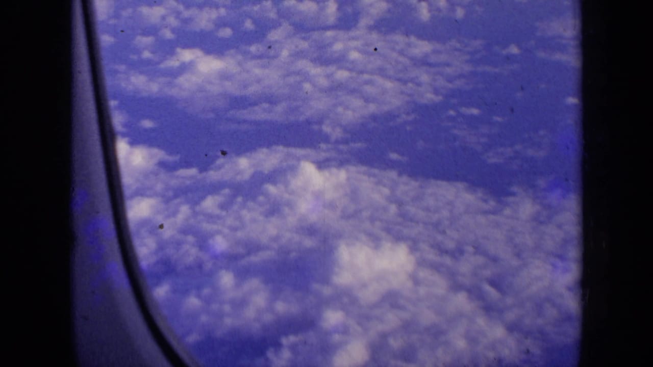 Clouds and sky seen through an airplane window.