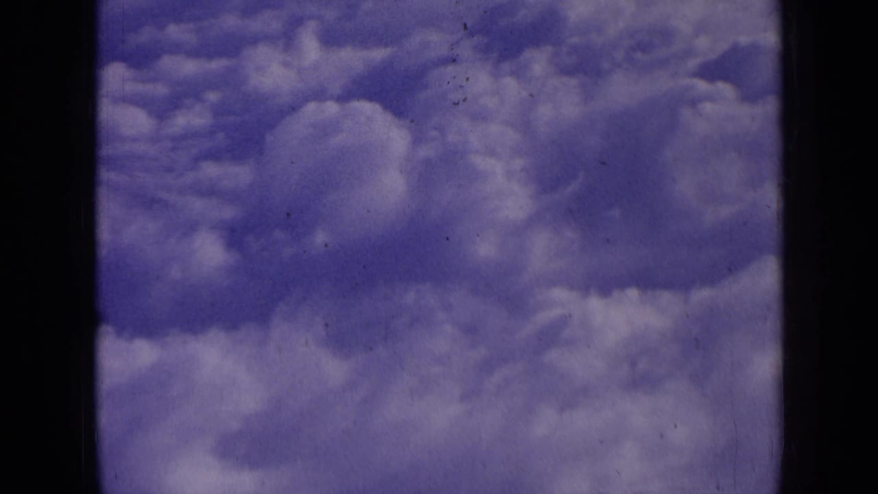 Puffy clouds in a blue-purple sky with black 8mm frame borders.