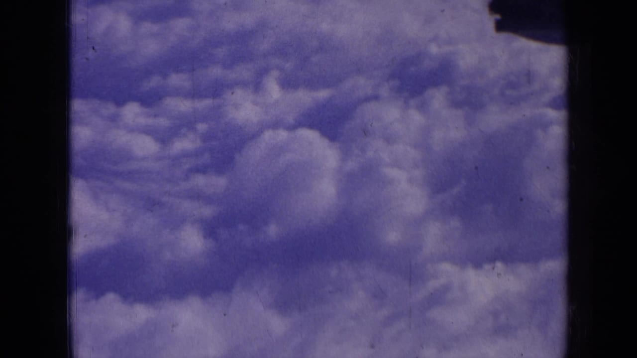 Cloud formations across a blue-purple sky with dark film edges.
