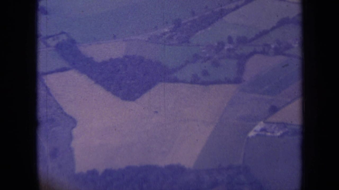 Aerial view of patchwork fields and hedgerows with dark frame edges.
