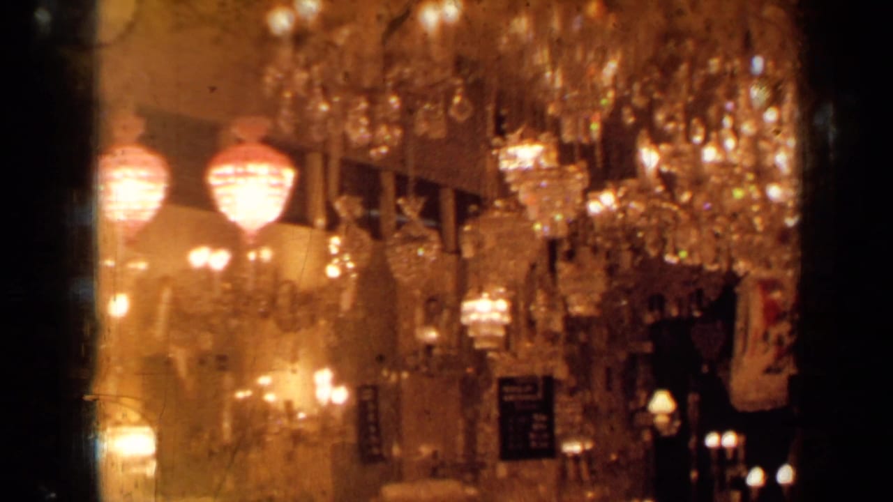 Warmly lit chandelier showroom with crystal fixtures and wall lamps.