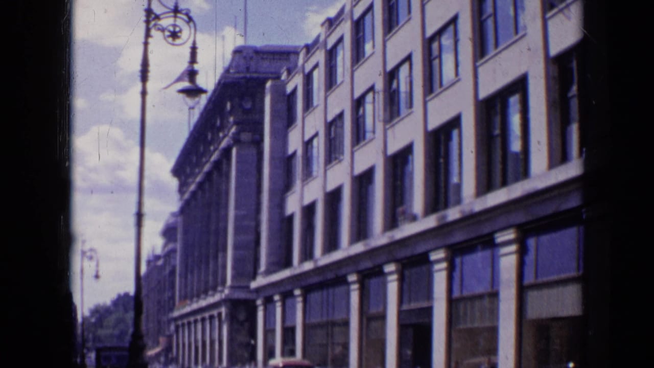 Street-level view of a multi-story building with windows and tall lamp posts.