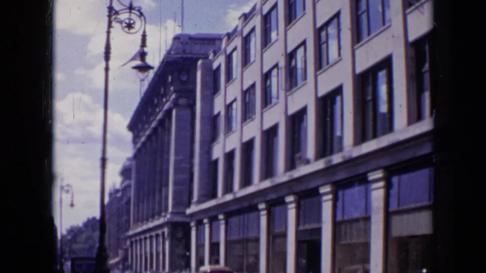 London street view from 1963 showing a multi-story building facade, rows of windows, and decorative street lamps.