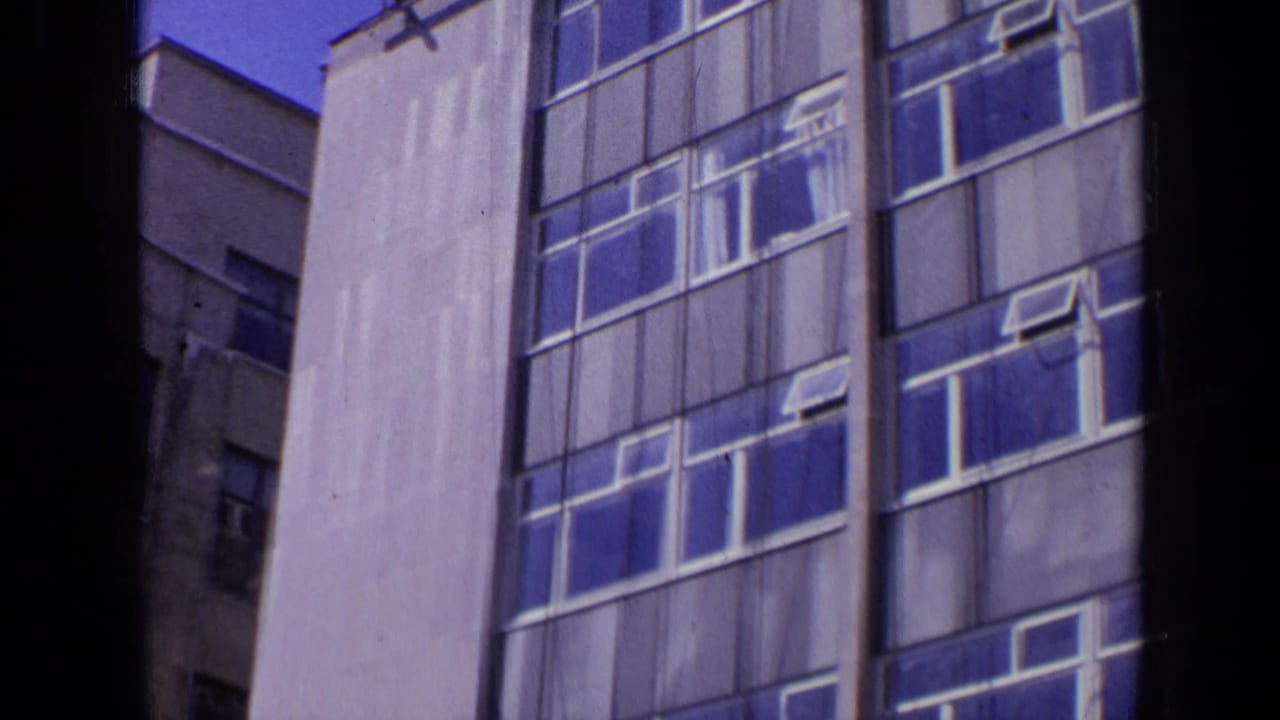 Tall building facade with blue windows and dark vertical foreground edges.