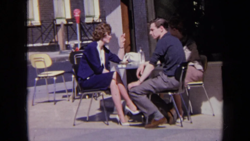 A candid 1963 London street moment shows the pair conversing at a small outdoor cafe table.