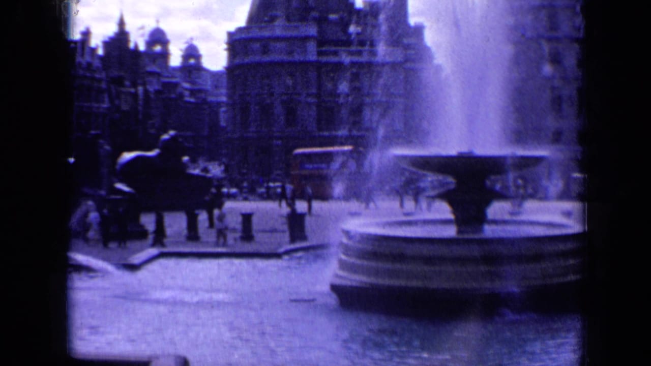 A 1963 London square scene frames the fountain basin at right with people and traffic moving near ornate buildings.