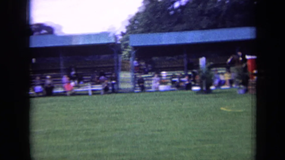 The 1963 London home movie view holds on the covered spectator stand and grassy equestrian course, with the horse partly distant at frame edge.