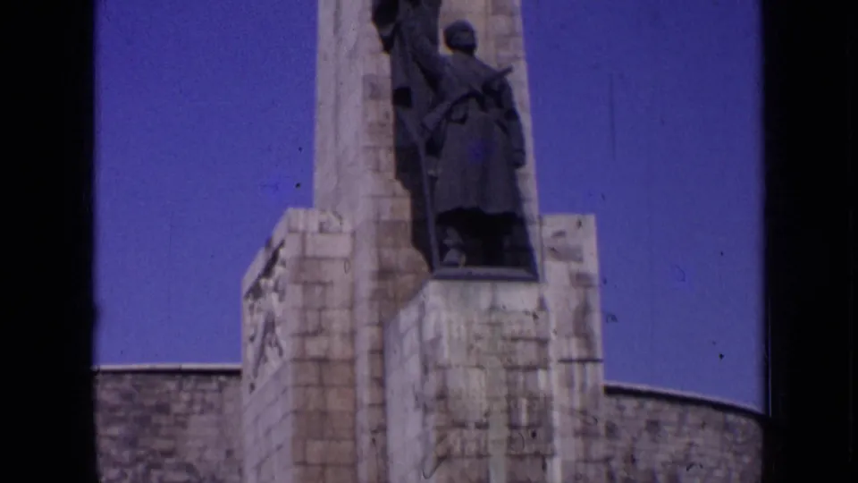 Closer 1963 Russia frame showing stone memorial architecture and a soldier figure with a rifle seen from below.