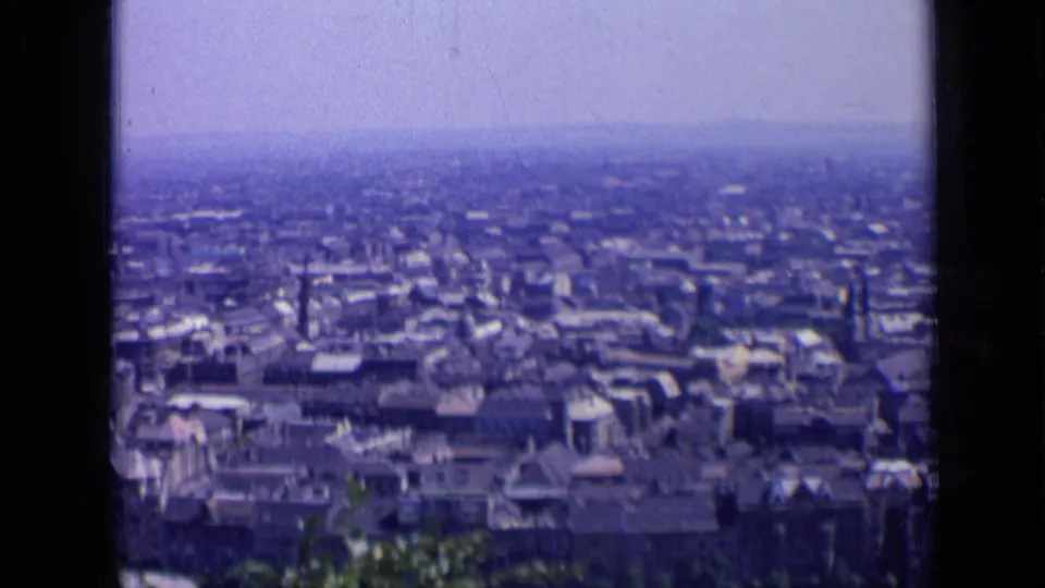 1963 Russia 8mm still with dense city blocks stretching toward a hazy horizon from a high vantage point.