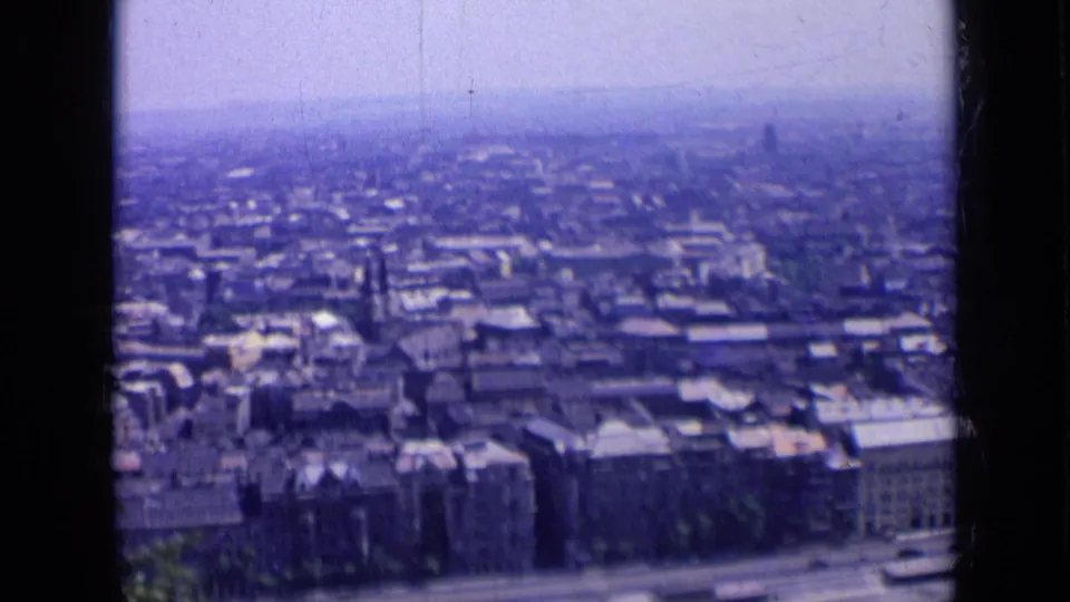 1963 Russia 8mm frame showing an elevated panorama of city buildings, foreground trees, and distant haze.