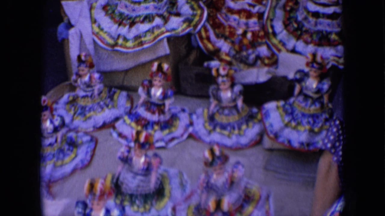 Rows of colorful handmade dolls arranged on a street display table.