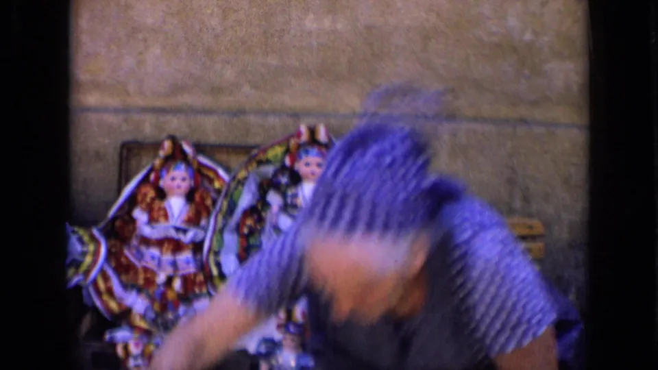 A woman vendor in a polka-dot dress and headscarf bends over handmade dolls in this 1963 Russia market view.