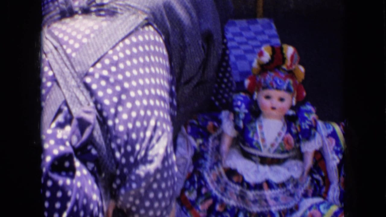 Colorful traditional doll beside a person wearing a polka-dot dress.