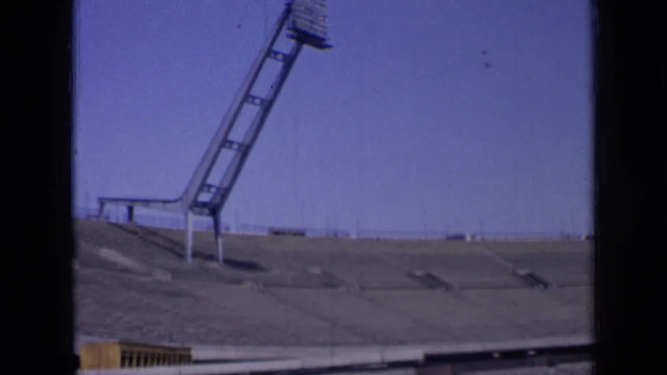 1963 Russia 8mm frame with a floodlight mast above empty stadium seating and a clear sky.