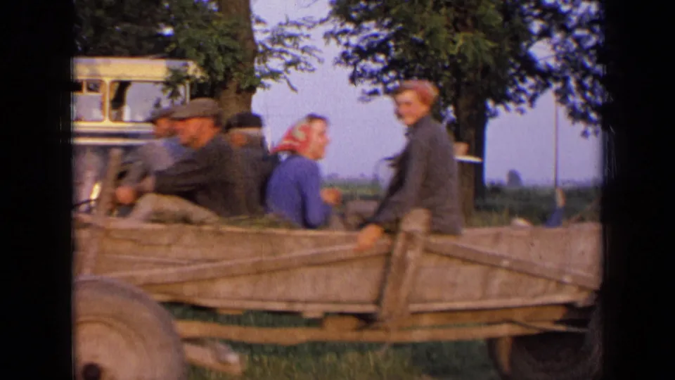 Open wagon with several visible riders, including a woman in a headscarf, traveling through the Russian countryside in 1963 footage.