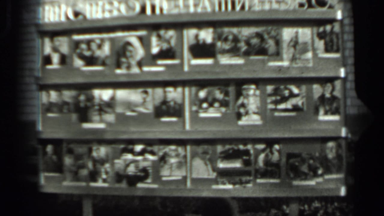 1963 Russia home-movie frame of a magazine or photograph stand, filmed from a fixed outdoor viewpoint in soft black-and-white focus.