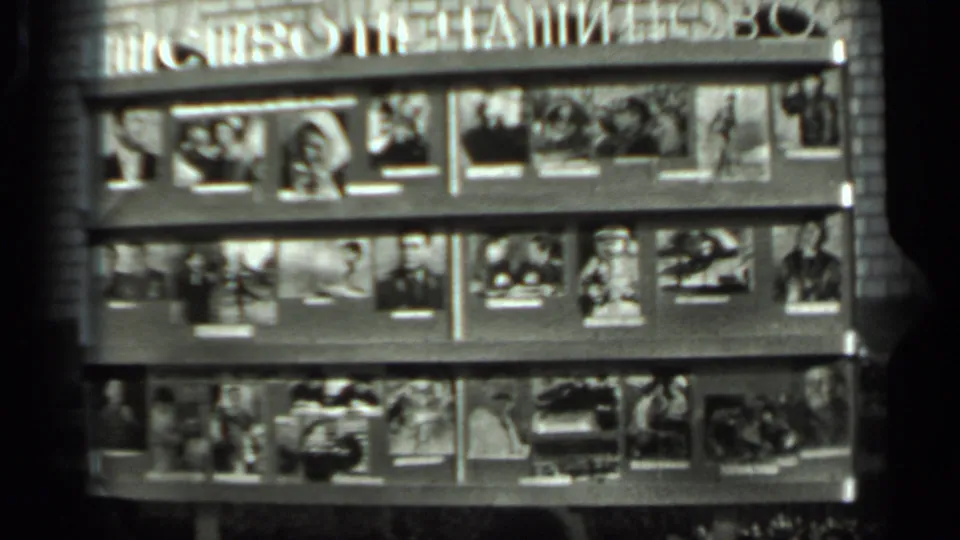 1963 Russia 8mm still showing a dense public display of magazines or photographs, with Cyrillic signage partly visible at the top.