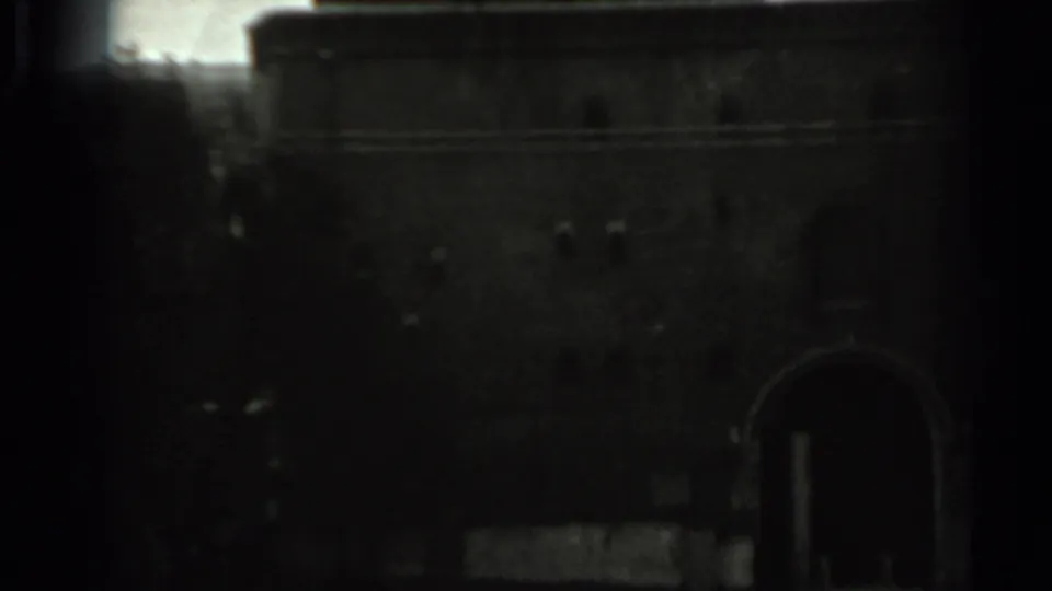 The final frame shows a shadowed architectural wall or gate-like structure, partly obscured by dark film edges.