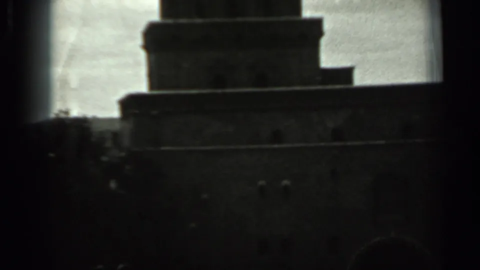 1963 Russia 8mm frame showing the upper mass of a tall stepped tower silhouetted under overcast sky.