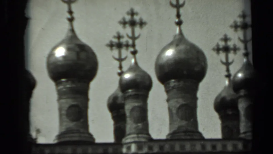 1963 Russia 8mm frame showing Russian Orthodox onion domes and crosses seen through dark foreground framing.