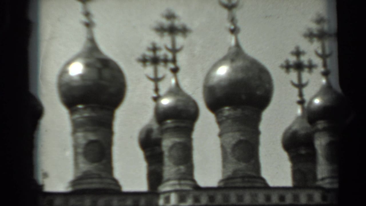 Cluster of onion domes with crosses and a dark vertical film edge.
