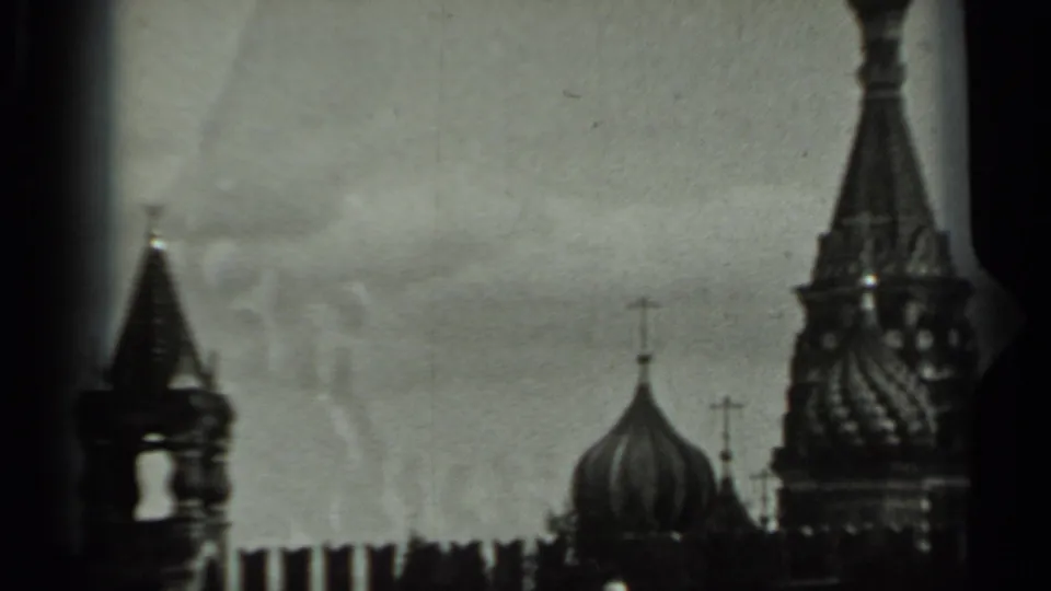 1963 Russia 8mm frame with a bell tower silhouette, Orthodox domes, crosses, spire, and Kremlin-like wall line.