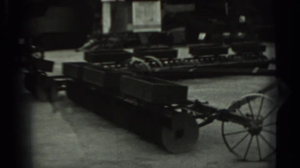A display of older farm machinery appears in Russia, 1963, including metal frames, wheels, and plow or trailer parts.