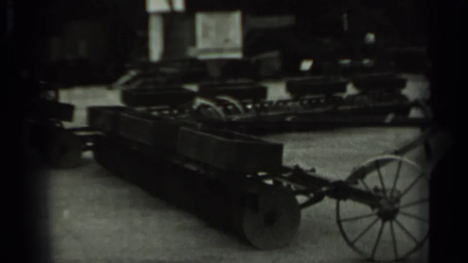 Vintage agricultural equipment remains in view, with wheeled metal implements arranged in a display setting in Russia, 1963.