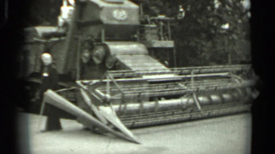 Close view of a large tracked agricultural machine and header in 1963 Russia archival home-movie footage.