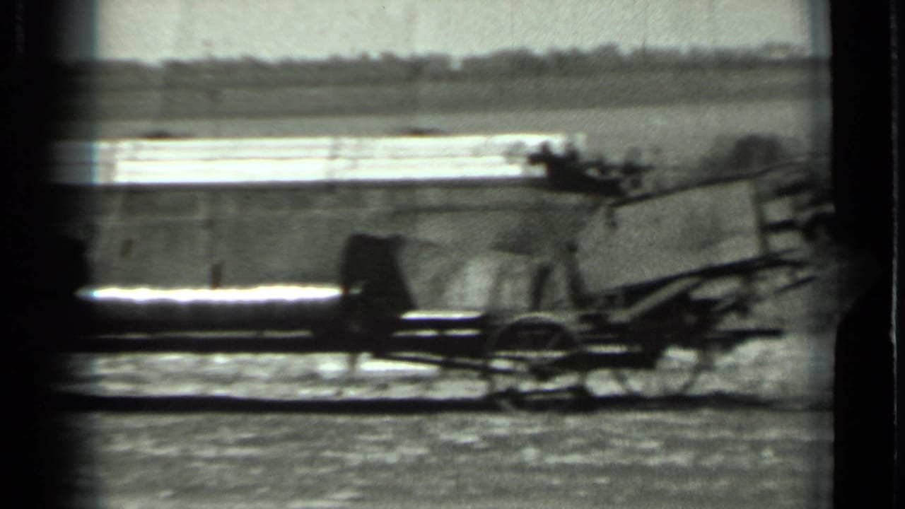 A long mechanical part of agricultural equipment stretches across the frame in rural Russia, based on clip metadata.