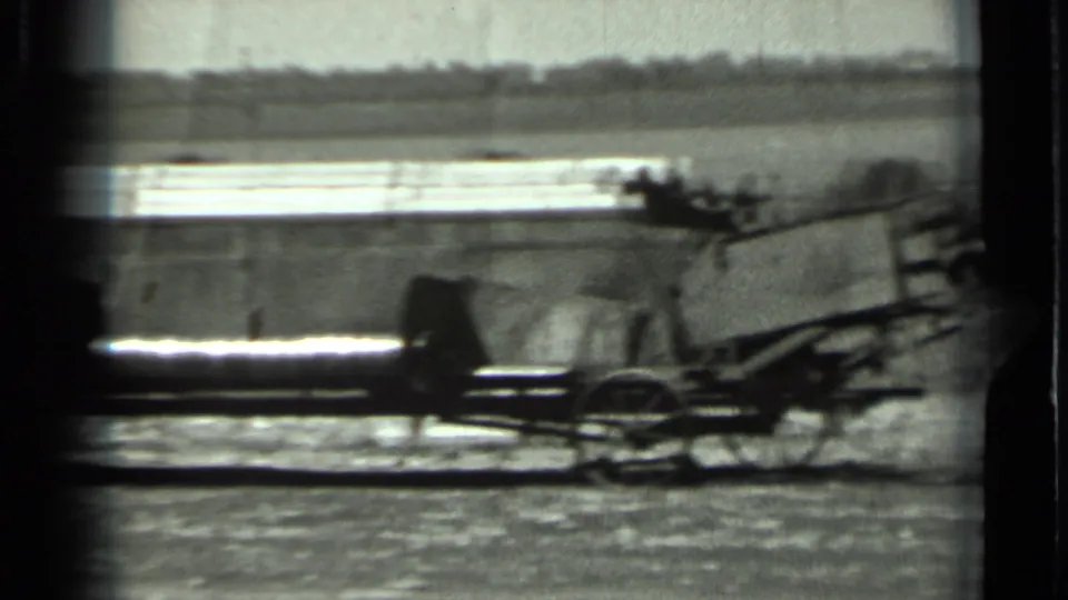 A long mechanical part of agricultural equipment stretches across the frame in rural Russia, based on clip metadata.