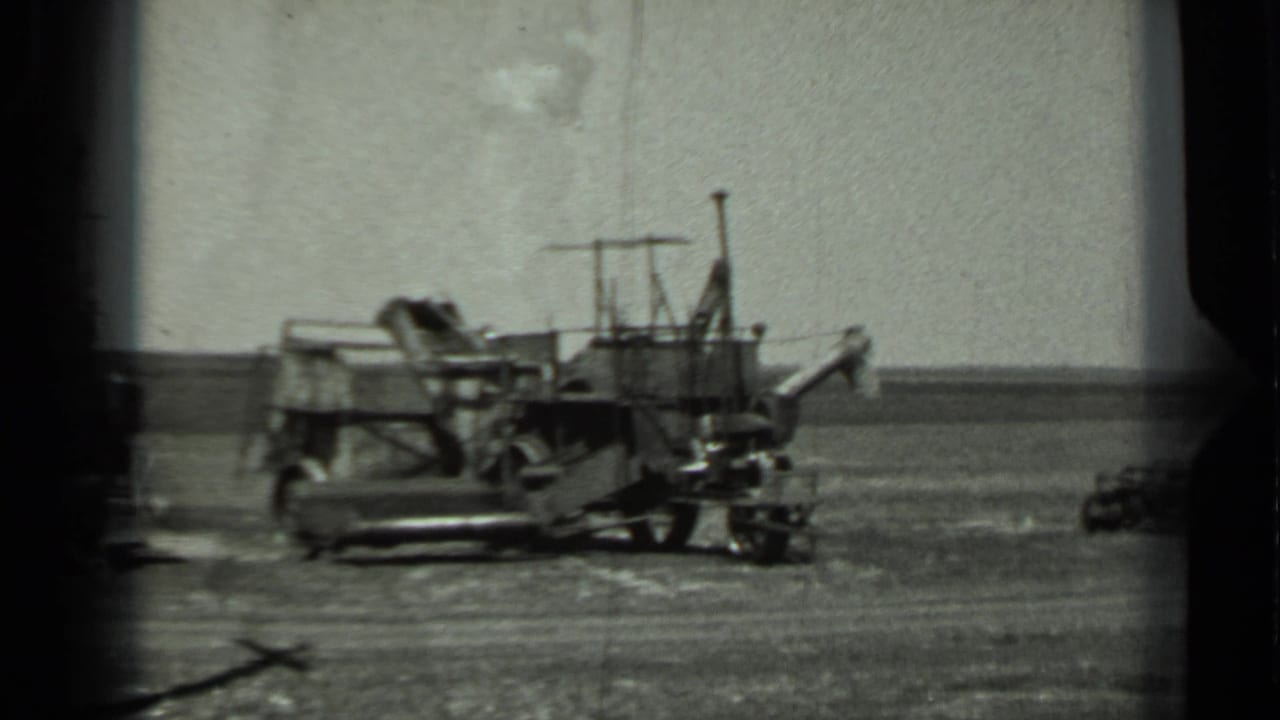 1963 Russia 8mm frame with a military-looking vehicle parked in a wide open field under a pale sky.