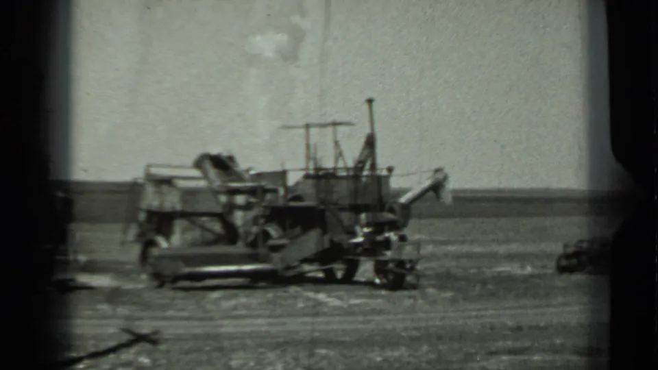 1963 Russia 8mm frame with a military-looking vehicle parked in a wide open field under a pale sky.