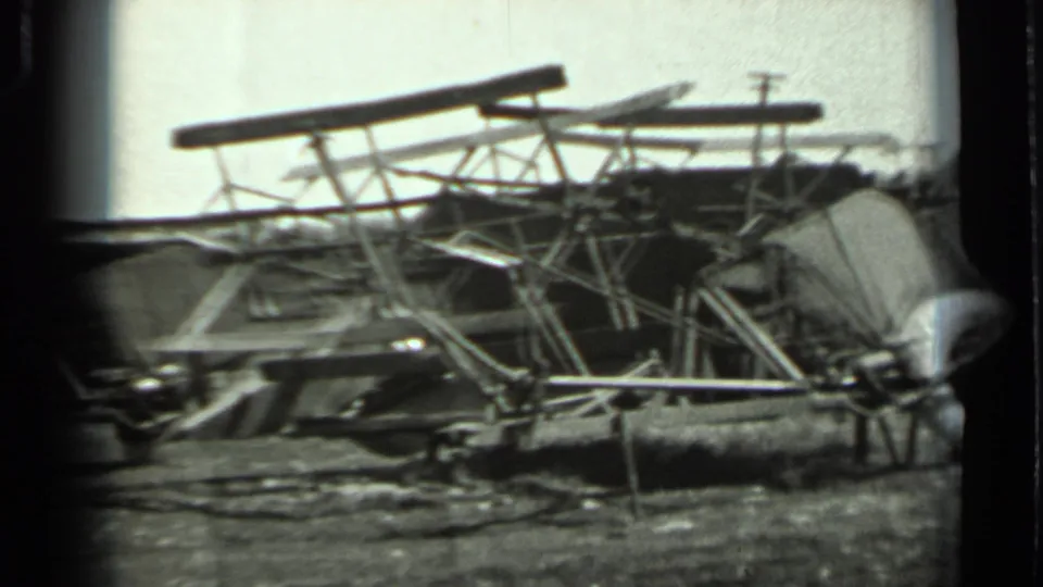 1963 Russia 8mm frame with tangled metal frames, long beams, and scattered parts in an outdoor field setting.