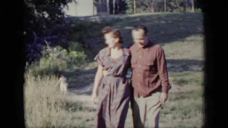Near the end of the clip, the adult couple appears close to the camera in a sunny New York outdoor home-movie scene.