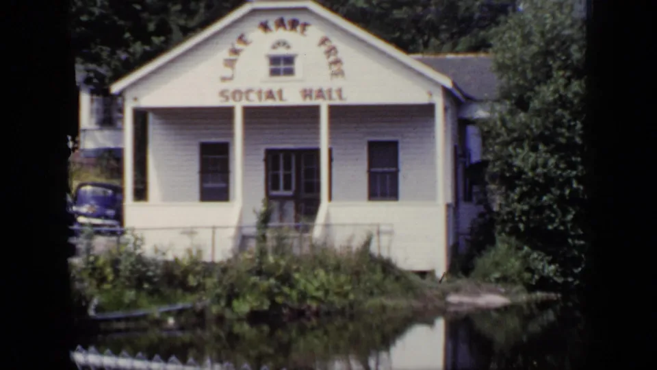 Lake Kari Free Social Hall in New York, seen across pond water in a 1948 8mm home-movie frame.