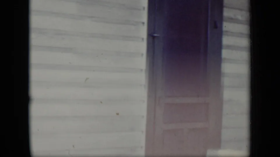 A closer 1948 New York view shows clapboard siding and a dark screen door, with soft focus and faded home-movie color.