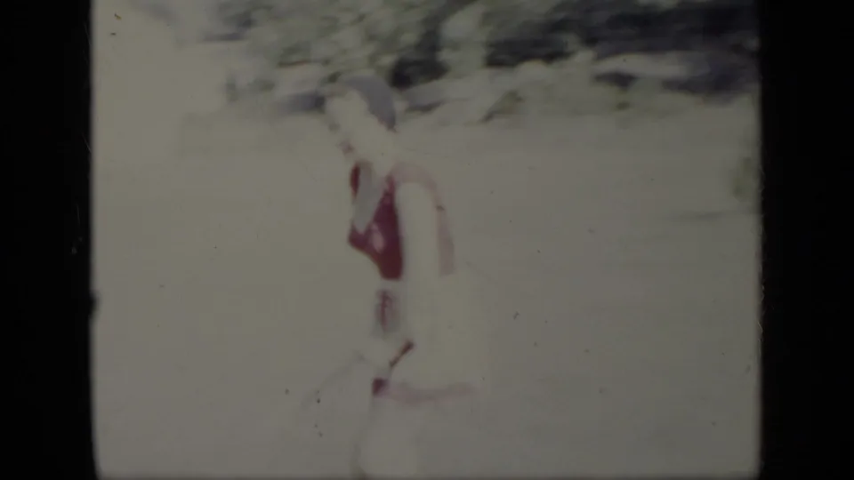 A 1948 New York frame shows the woman in a swimsuit moving sideways through a bright outdoor yard, with foliage behind her.