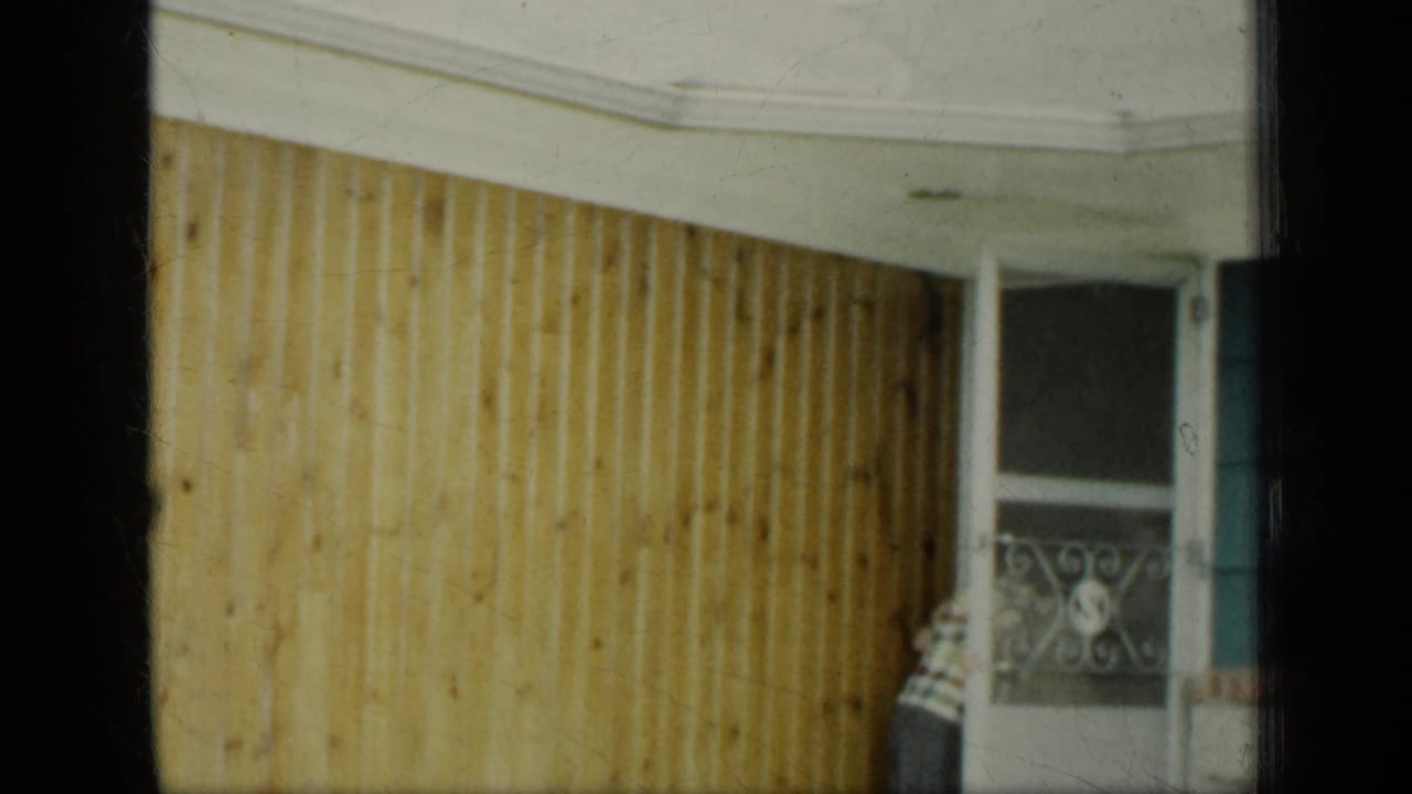 Woman near a porch with light wood siding, white trim, and a decorative screen door.
