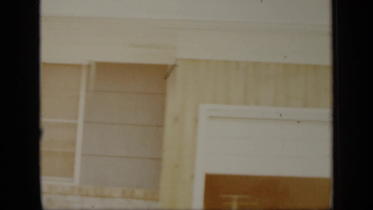 Wood-sided house exterior with a window and part of a garage door.