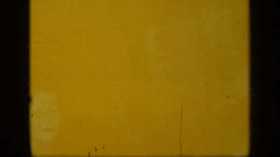 Warm yellow 8mm frame with dark edges, likely a transitional or underexposed opening moment from the 1948 New York reel.