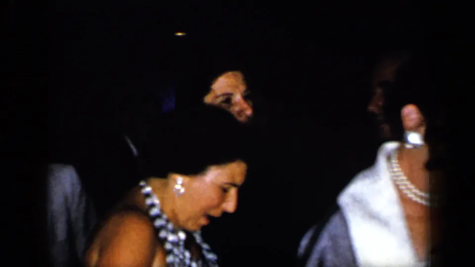 1948 New York reception footage showing women in formal dresses and jewelry among shadowed guests.