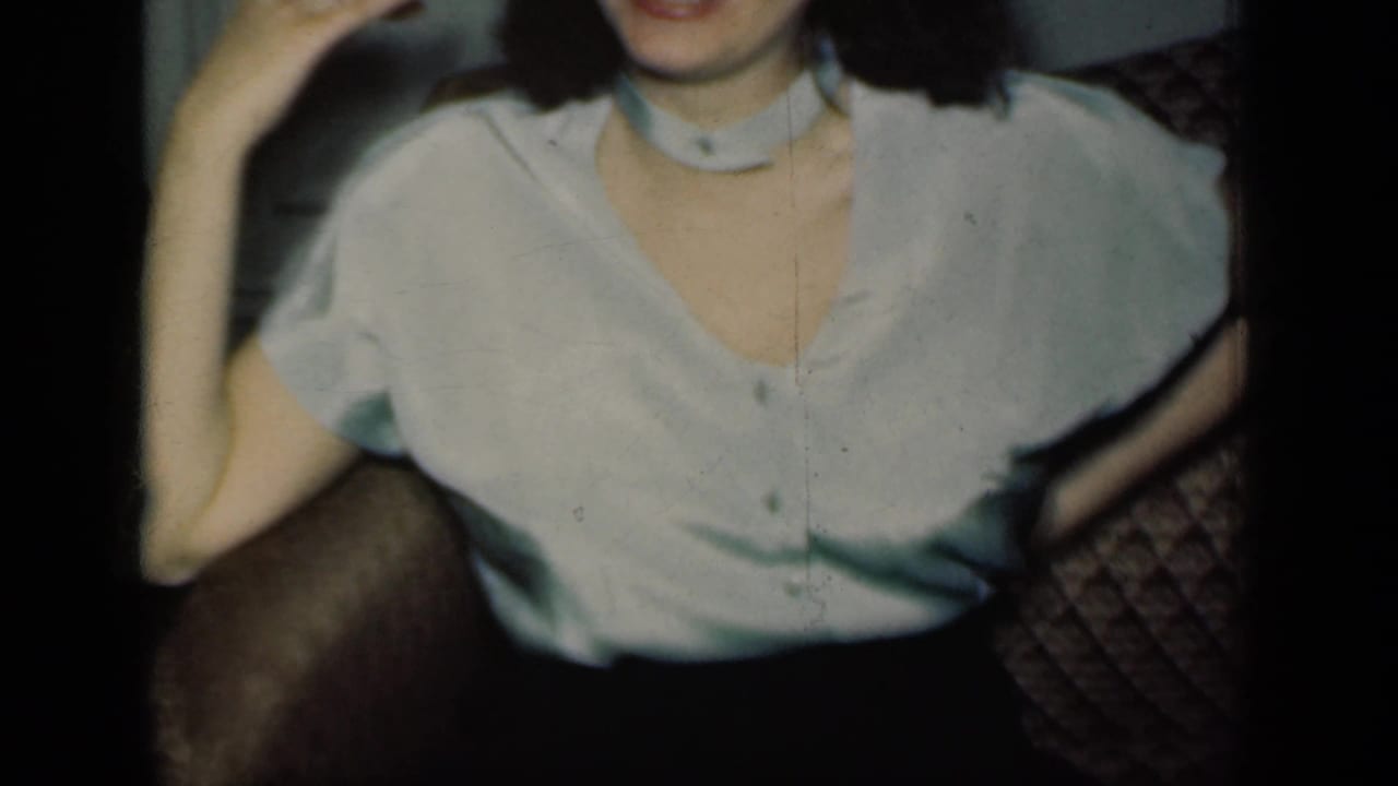 Cropped view of a woman seated on a sofa with one arm raised.