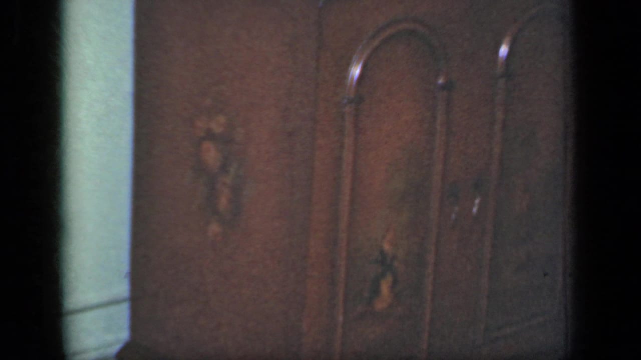 Dark wardrobe doors with arched paneling and small decorative inlays fill the 1949 New York interior frame.
