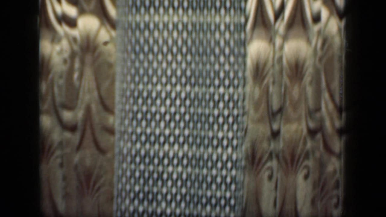 Close view of patterned curtains and a darker woven or textured curtain panel.