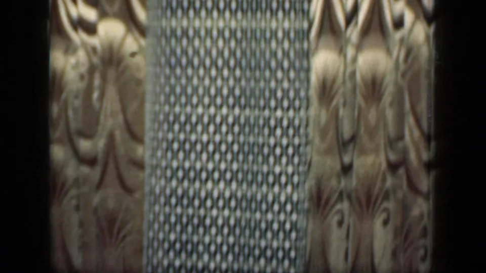 Close interior detail from a 1949 New York home, with ornate curtain fabric beside a darker woven or patterned textile panel.